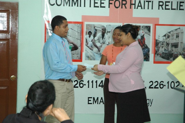 Minister Manickchand receives donation from a Representative of Kaieteur News.