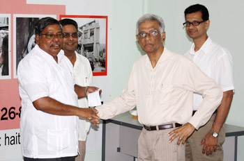 Pandit Reepu Daman Persaud presents a cheque of $500,000 on behalf of the Guyana Hindu Dharmic Sabha, to CDC Director, Colonel Chabilall Ramsarup at the CDC Headquarters.