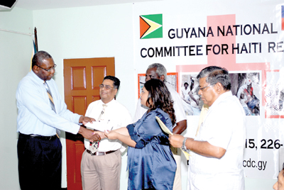Another Bank representative hands over a cheque to Human Services Minister Priya Manickchand