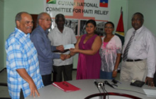 President of the Guyana Gold and Diamond Miners Association, (GGDMA) Norman McLean hands over the cheque to Chairperson of the Guyana Committee for Relief for Haiti. Also in photo is Pastor Raphael Massiah (extreme right) Executive Director of GGDMA, Edward Shields. Minister of Public Works Robeson Benn is third from left.